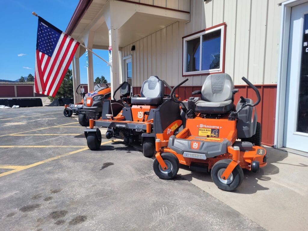 Husqvarna zero-turn mowers displayed outside Black Hills Equipment Rentals in Spearfish, SD, available for new equipment sales.