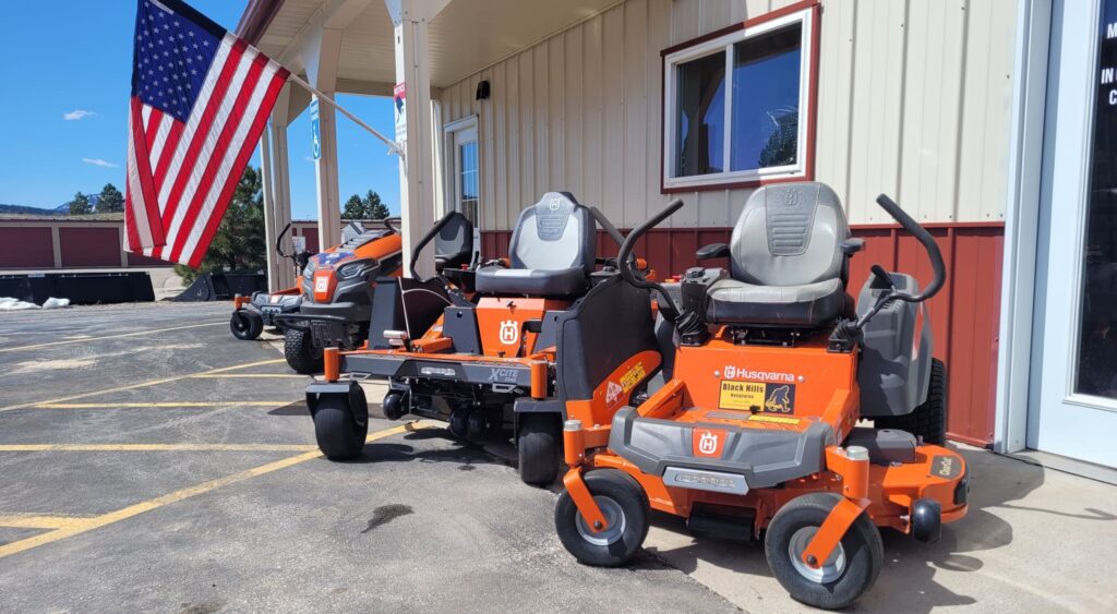 Husqvarna zero-turn mowers displayed outside Black Hills Equipment Rentals in Spearfish, SD, available for new equipment sales.
